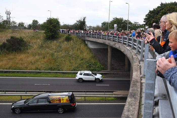 Members of the public stand on a bridge in Kinross overlooking the M90 motorway.