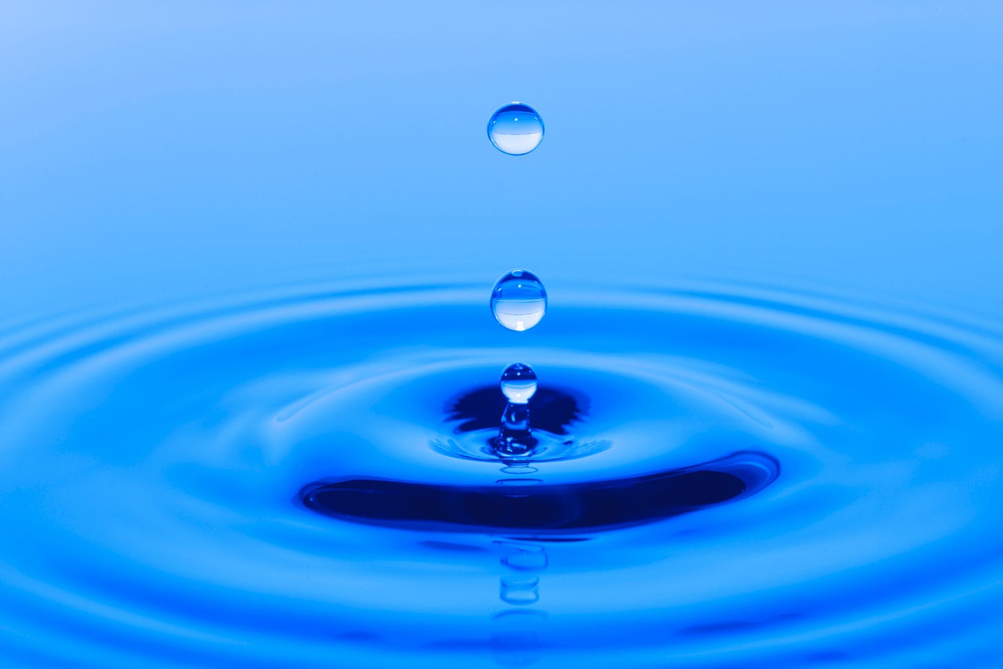 drops of water making ripples in deep blue water