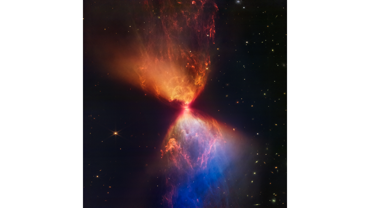 A forming protostar surrounded by a large hourglass-shaped nebula. A bright orange object, the protostar, lies at the center of this image. In front of the protostar is a thin grey line, which is the protostar’s accretion disk. Above the protostar is an orange, triangular cloud of gas that points to the top left of the image. The area closest to the protostar is a brighter orange than the area to the top left, and has more pronounced plumes of orange gas. Below the protostar is another triangular cloud of gas that points to the bottom right of the image. The area closest to the protostar is a blend of pronounced blue and orange plumes of gas. Farther toward the bottom right, the color of the gas turns primarily blue. Stars and galaxies of many different shapes and sizes are scattered around the image, although they are noticeably more absent on the left side of the hourglass.