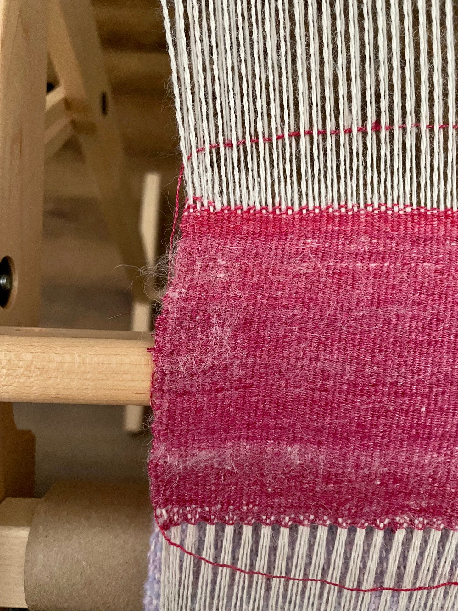 White warp threads with red weft. There's a noticeable draw-in.