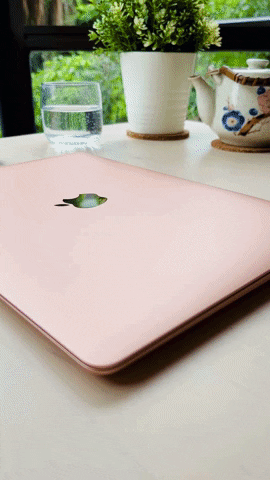 GIF of someone opening the cover of a MacBook Air. The iconic Apple logo appears as the computer is being started.