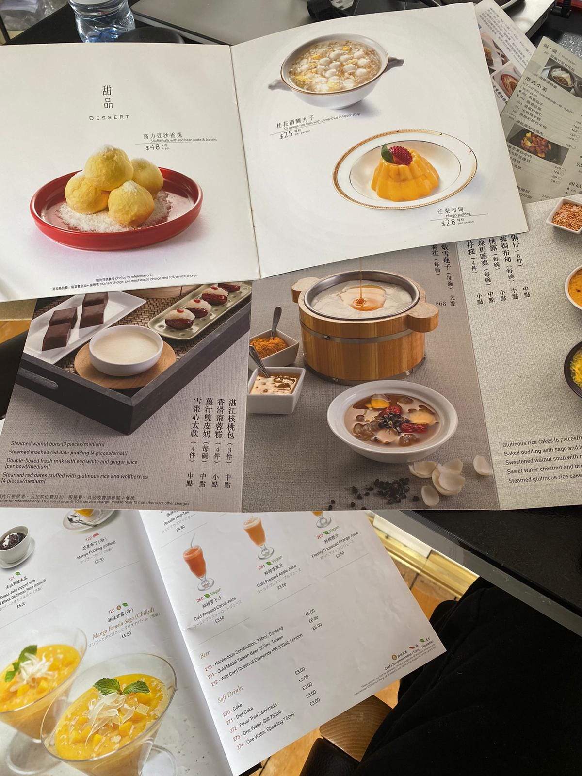 An overhead shot of several Hong Kong restaurant menus open to their dessert pages featuring photos and text