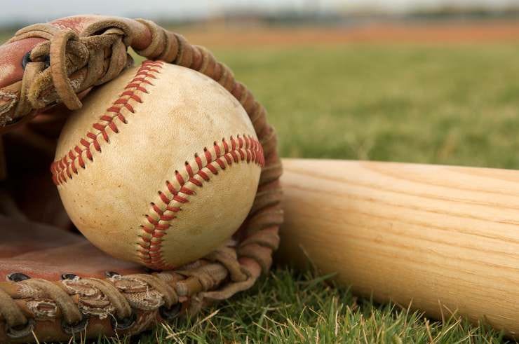 A baseball in a glove and a baseball bat lying on grass bedz2aq