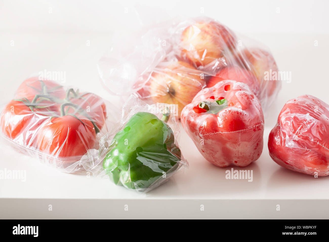 single use plastic packaging issue. peppers tomatoes apples vegetables in plastic  bags Stock Photo - Alamy