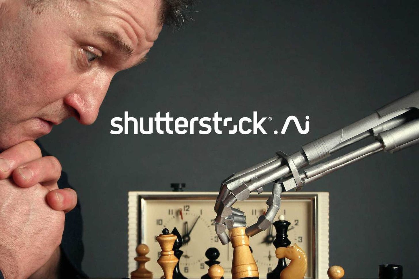 A stock image showing a robot playing chess against a human with the Shutterstock.ai logo superimposed on top. 