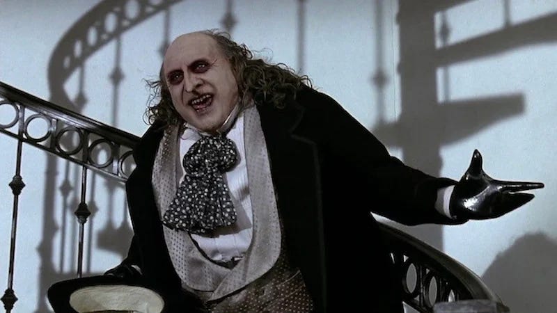 Danny DeVito as the Penguin, dressed in an old-fashioned suit with a prosthetic nose.