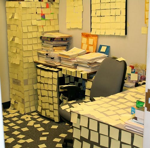 Office with yellow sticky notes on every surface.