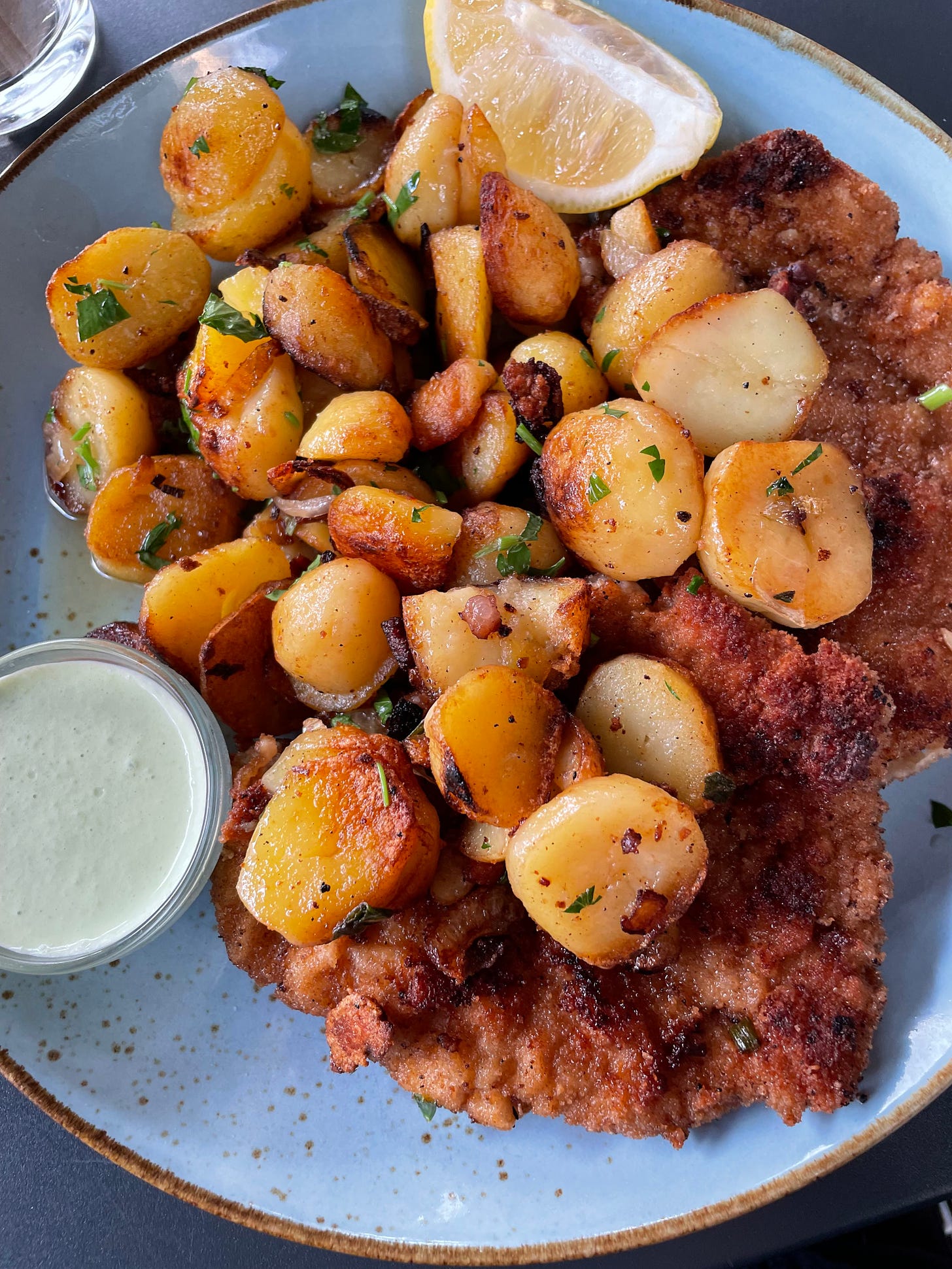 Fried schnitzel covered in roasted potatoes