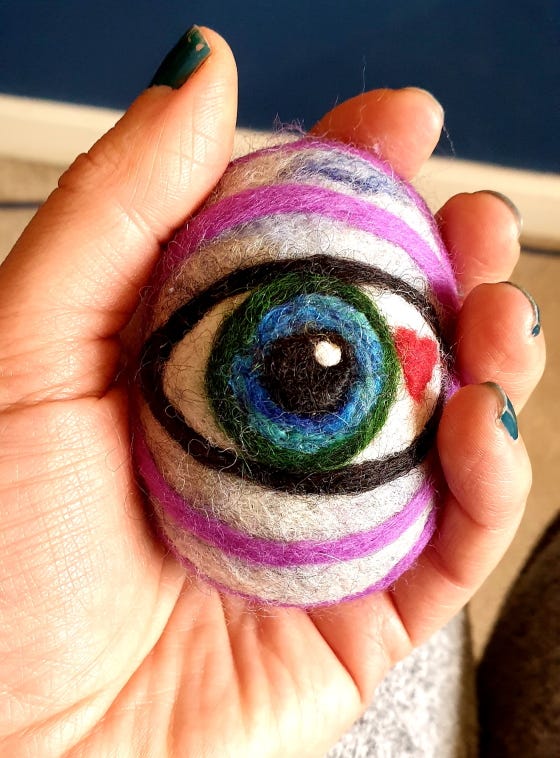 Needle felted eye of the seer held in a hand