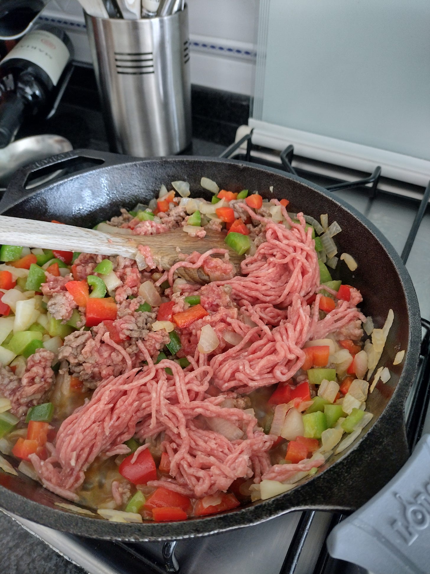 Pan on a stovetop with meat and vegetables
