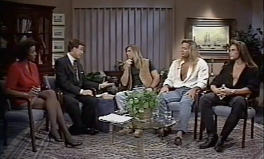 Romance author Sandra Kitt on a Philadelphia morning talk show. She is seated next to the host, Wally Kennedy, and three romance cover model hunks.