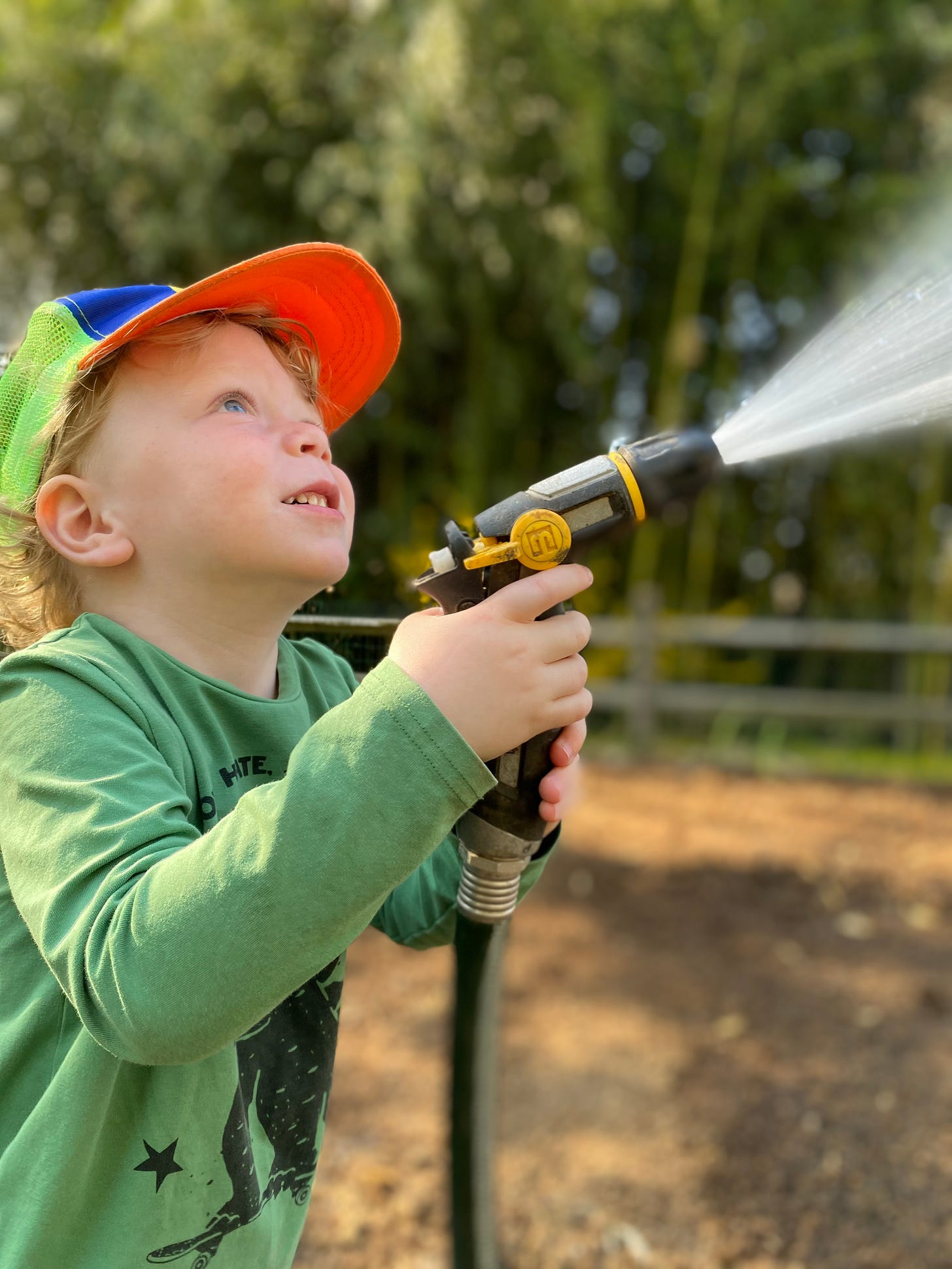 boy spraying garden hose