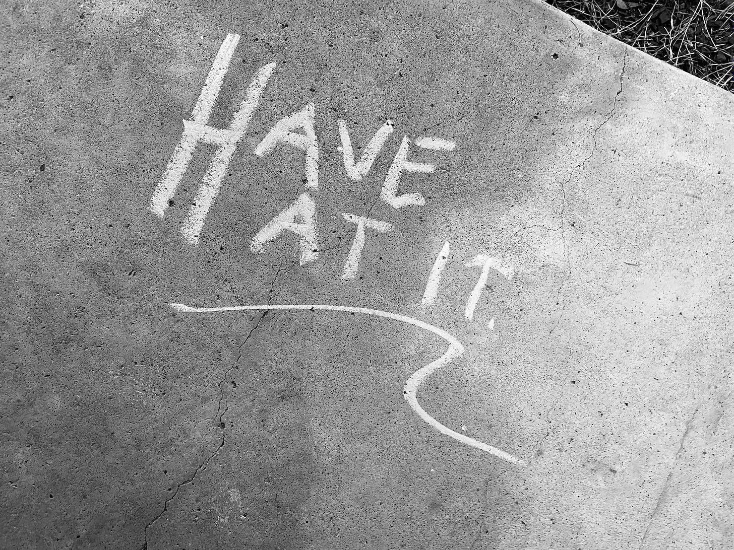 "have at it" written on concrete by chalk - black and white photo