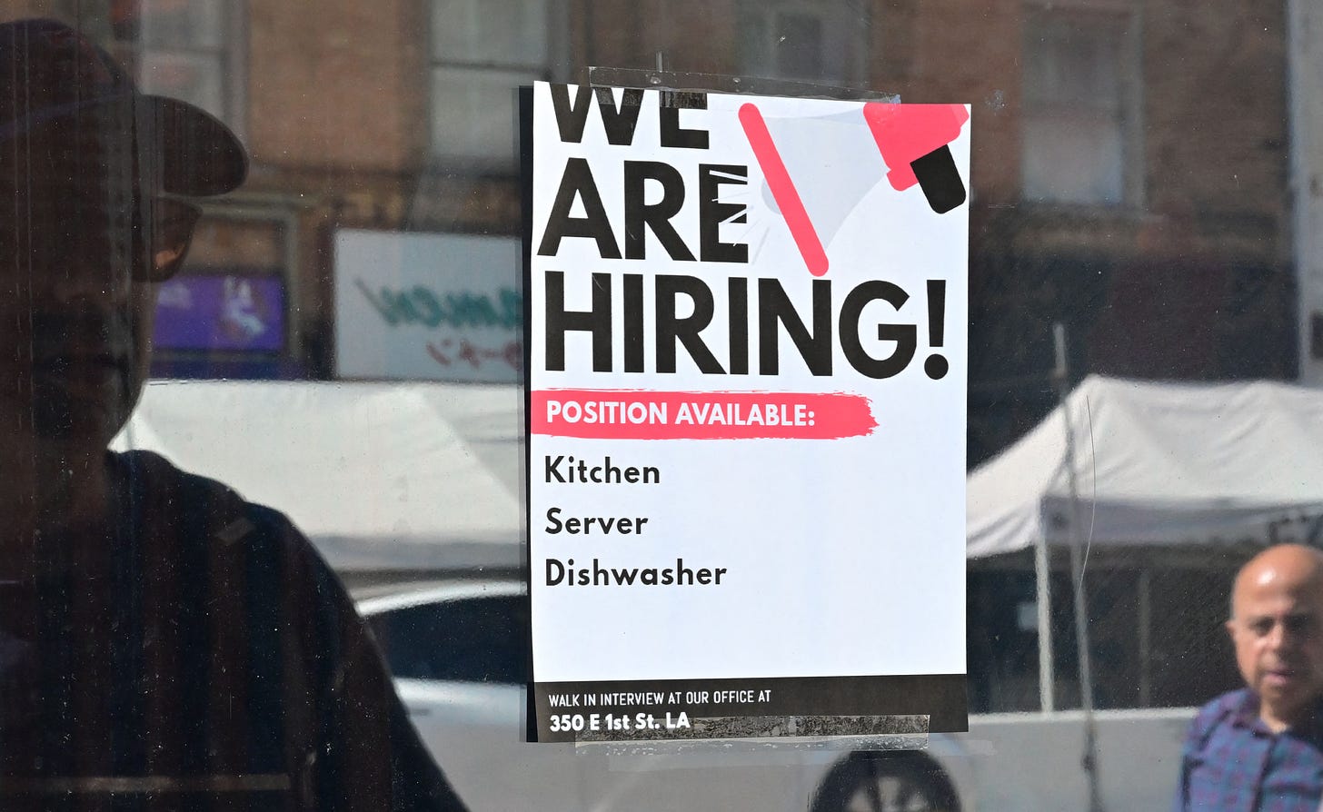 A "We Are Hiring" sign is posted in front of a restaurant in Los Angeles.