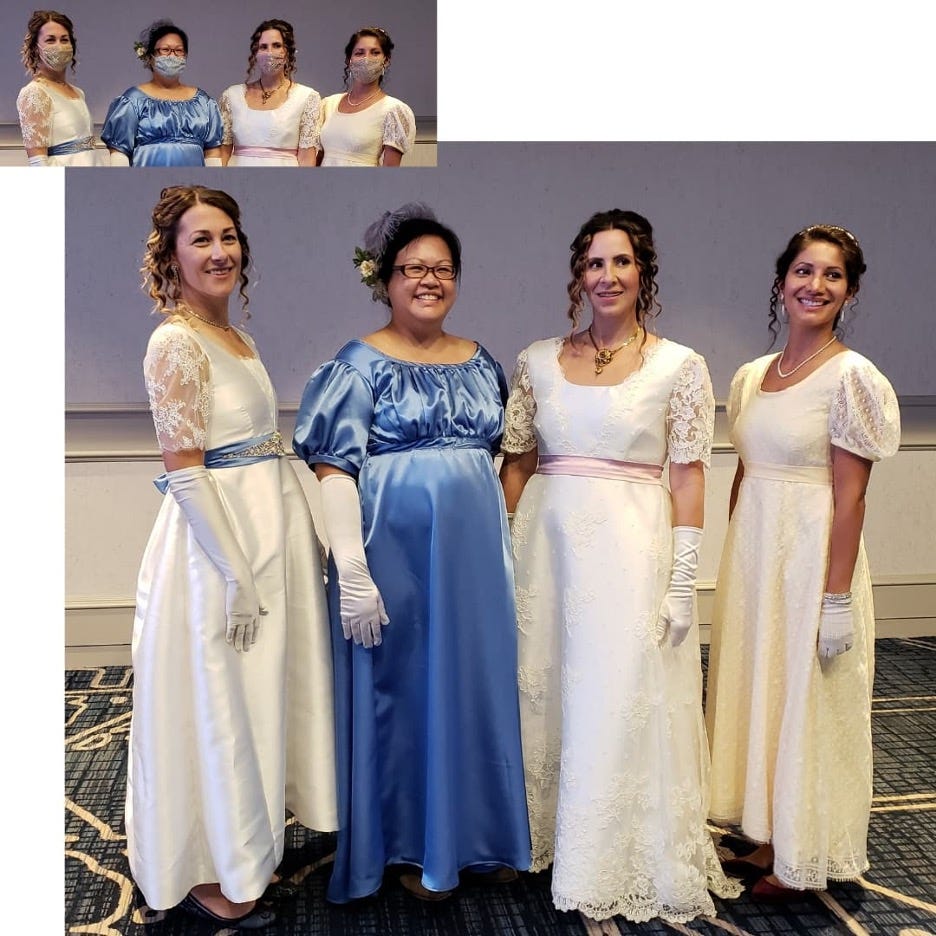 Designer Jennyvi Dizon models a periwinkle blue Regency-inspired gown, with three sisters-in-law, Kristin, Jillian, and Cori Cooper, wearing Dashwood gowns, inspired by 'Sense and Sensibility's' Marianne and Elinor Dashwood. The Dashwood gowns are white and one is pale yellow, featuring lace sleeves and wide sashes. The four are standing in a room at the Jane Austen Society of North America's annual general meeting. They are standing close together and smiling. 