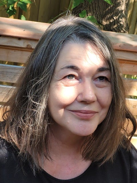 Author Susan Mockler smiling on a wooden porch and the sun shining on her face.