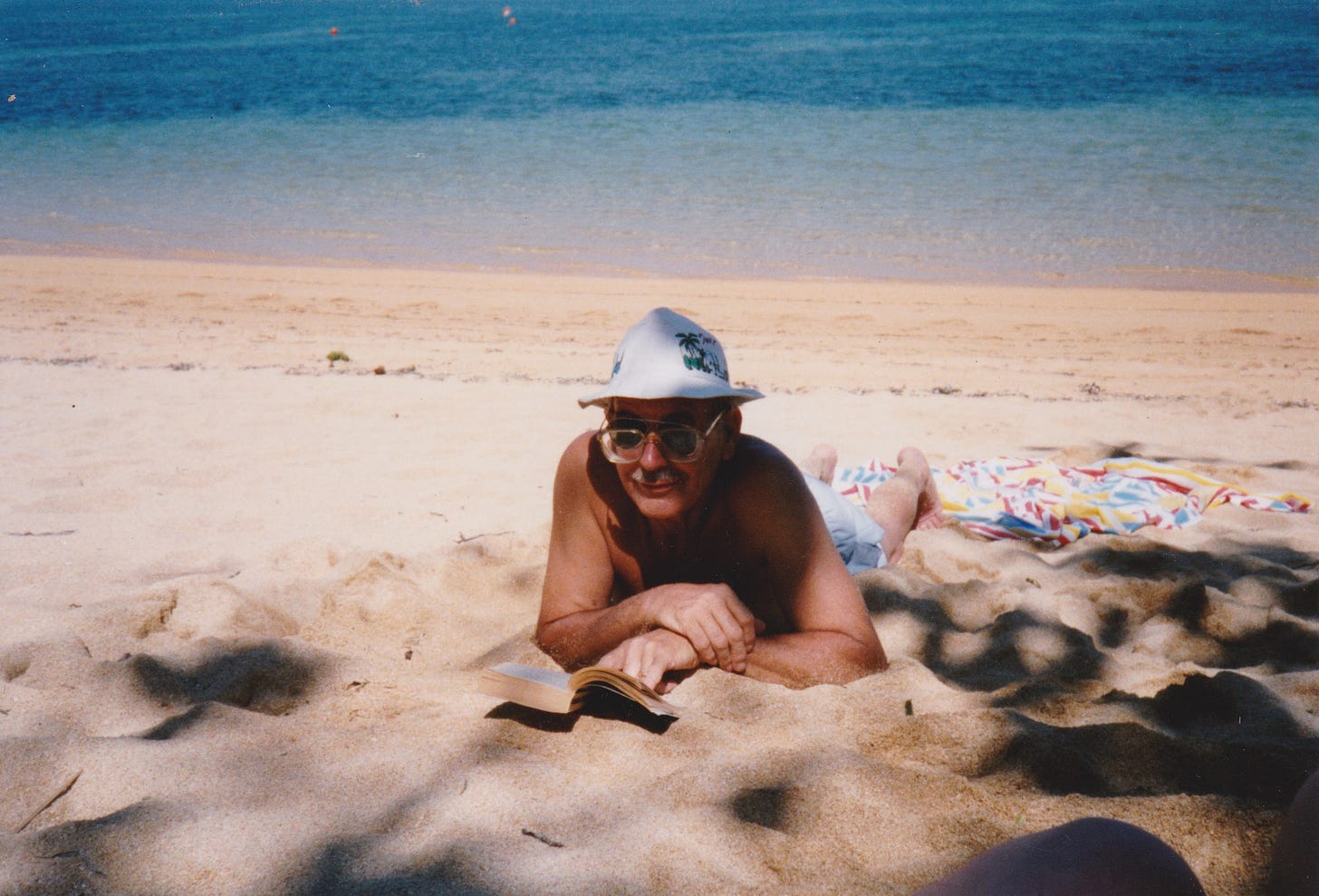 My father, Joseph Campbell, on a beach somewhere reading a book