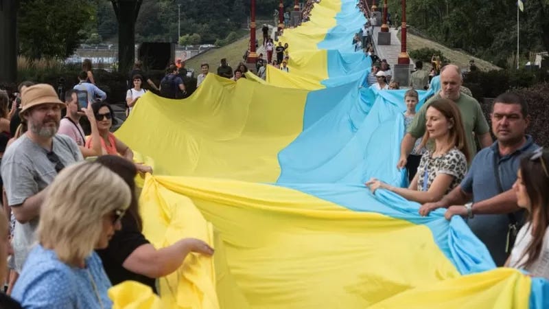 Ukrainians holding 430-metre-long state flag during action of unity 28 August. 