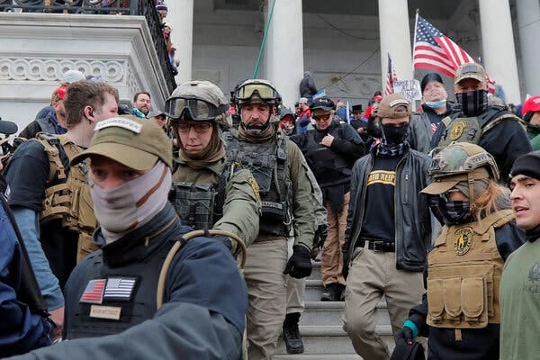 Jessica M. Watkins, second from left, and Donovan Crowl, center, march down the steps of the U.S. Capitol with the Oath Keepers militia group during the Jan. 6 riot.