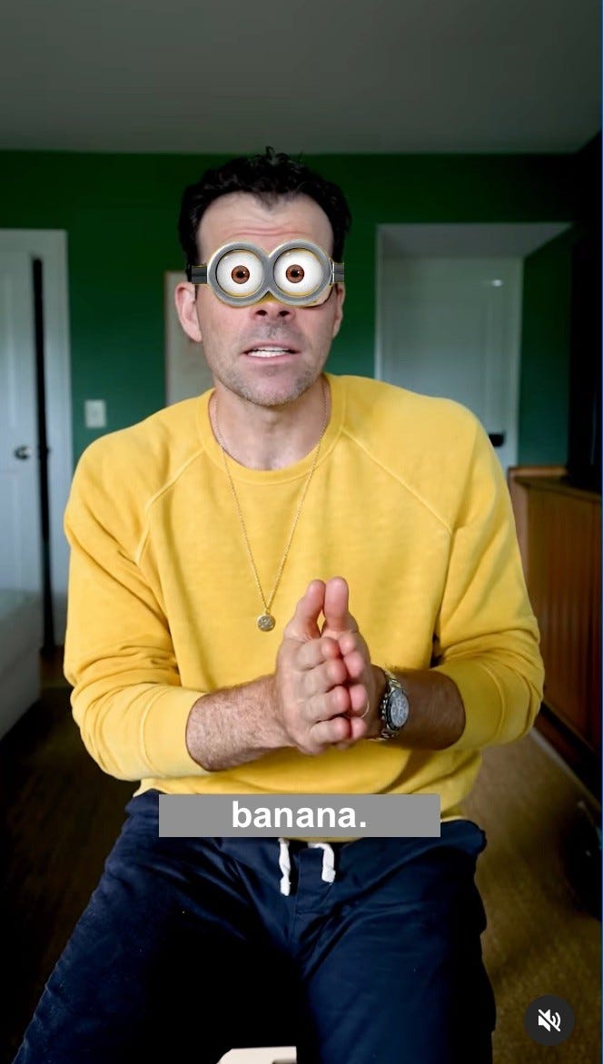 A still from Adam Mosseri’s instagram video where he wears a minion-yellow sweater and leans forward with hands together earnestly. His eyes are replaced by Minion goggle eyes, and the subtitle reads: “banana.”