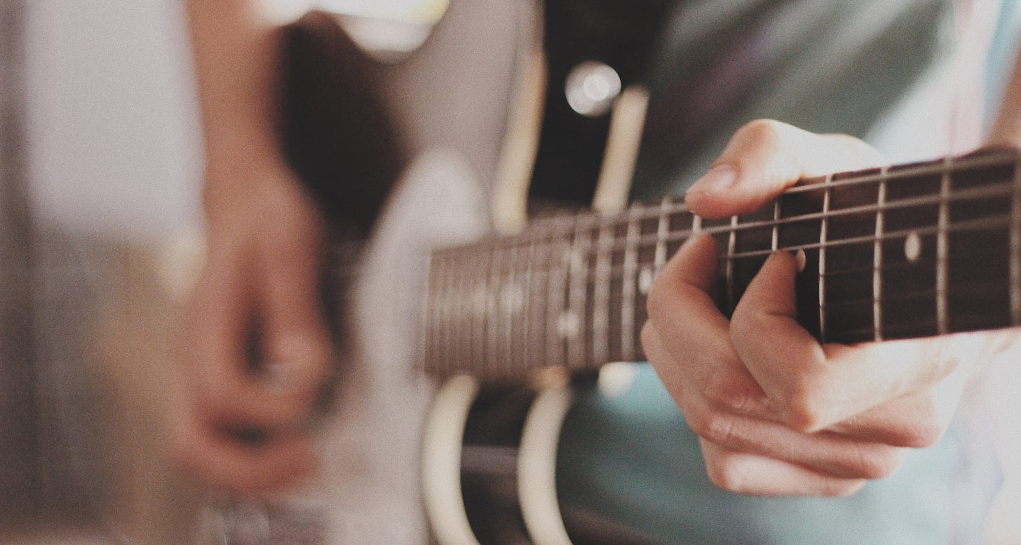 Close-up of hands playing an electric guitar