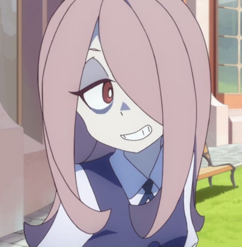 Screenshot of Such from Little Witch Academia. A young girl with light grey hair and bags under her eyes wearing a navy school uniform.