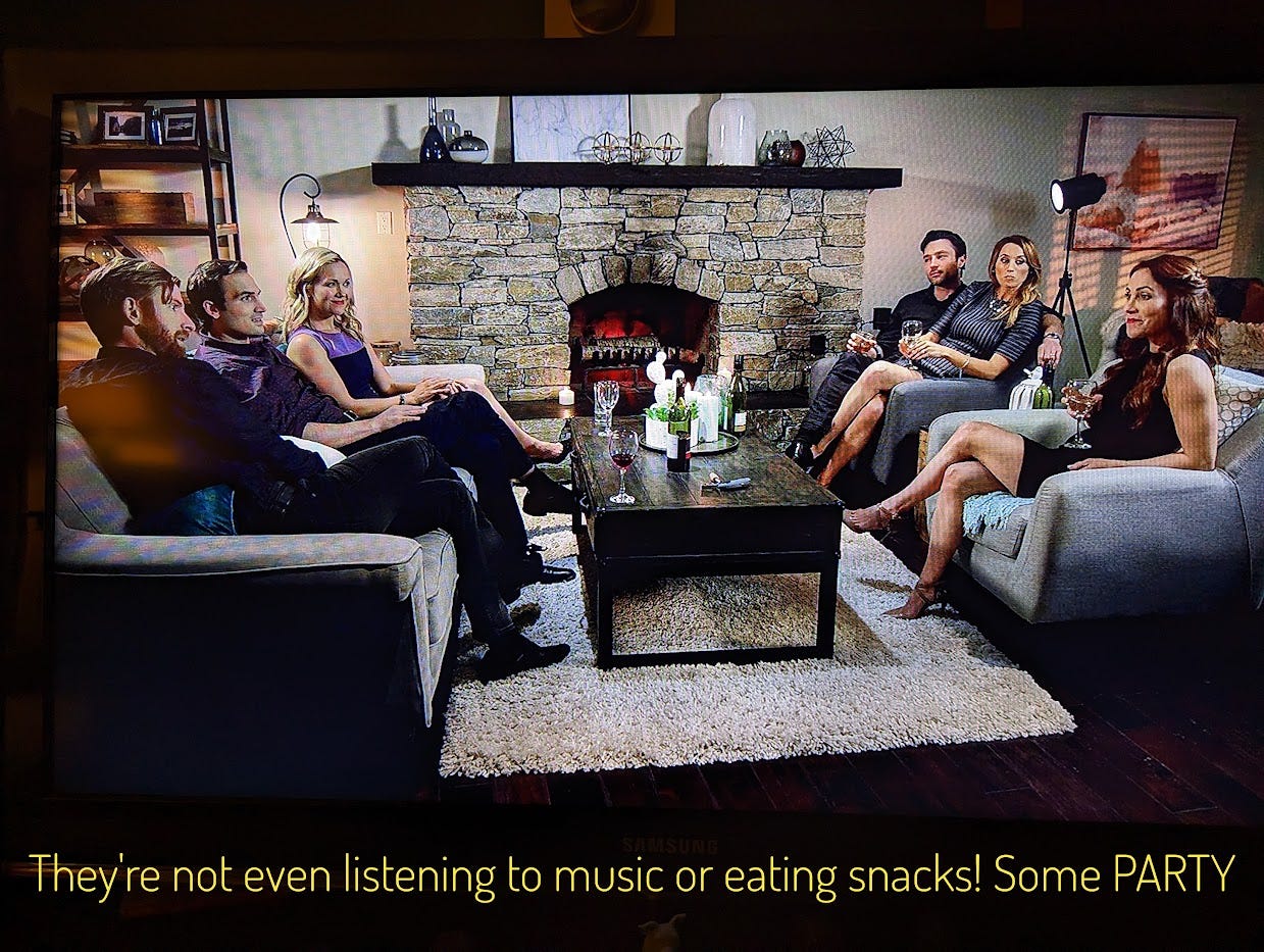 Six white people in their 30s sitting around a coffee table next to a big fireplace. They look strained. Captioned "They're not even listening to music or eating snacks! Some PARTY"