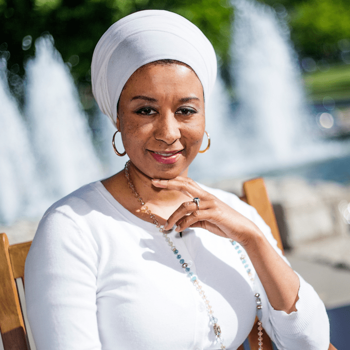 Aisha Sharif sitting in front of a water fountain.
