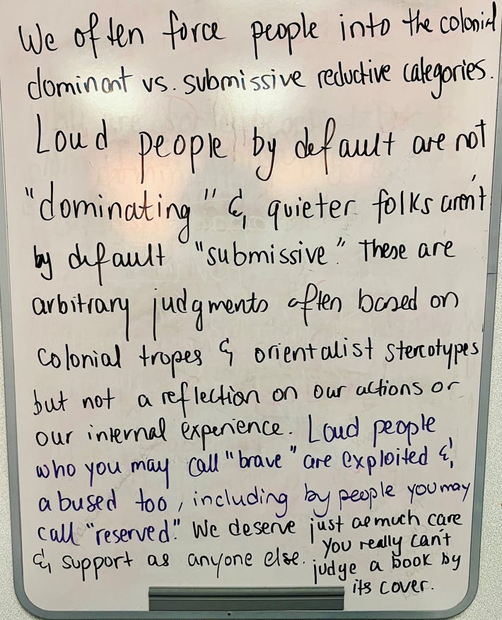 Ayesha’s writing on white board says “We often force people into the colonial dominant versus submissive reductive categories. Loud people by default are not dominating and quieter folks aren’t by default submissive. These are arbitrary judgments often based on colonial tropes and orientalist stereotypes but not a reflection of our actions or our internal experience. Loud people who you may call brave are exploited and abused too, including by people who you may call reserved. We deserve just as much care and support as anyone else. You really can’t judge a book by it’s cover.”