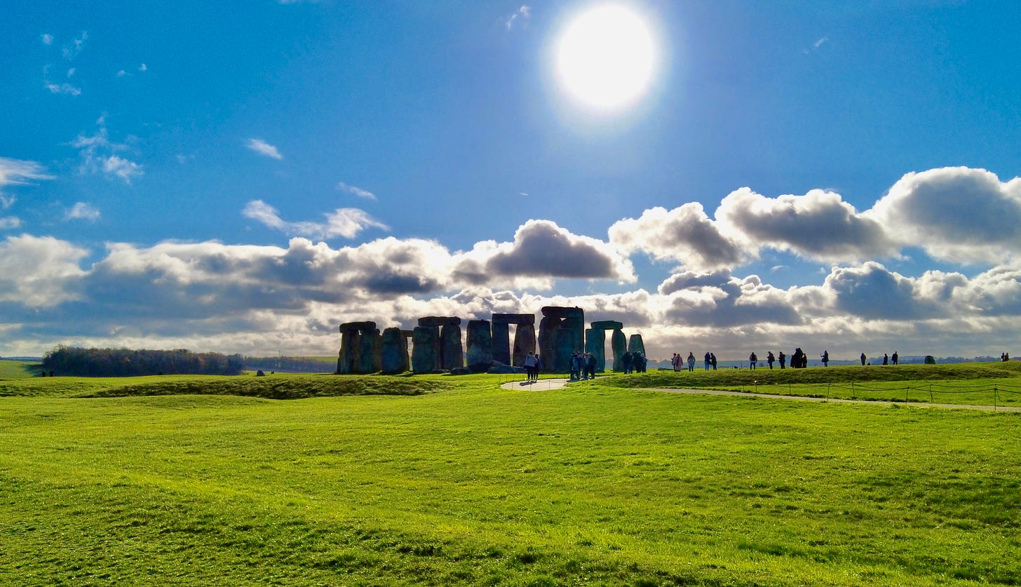 The November sun in a bright blue sky rising above the stone circle at Stonehenge, Wiltshire. Over 4000 years of history is here. Visited by millions these stones hold untold secrets.  