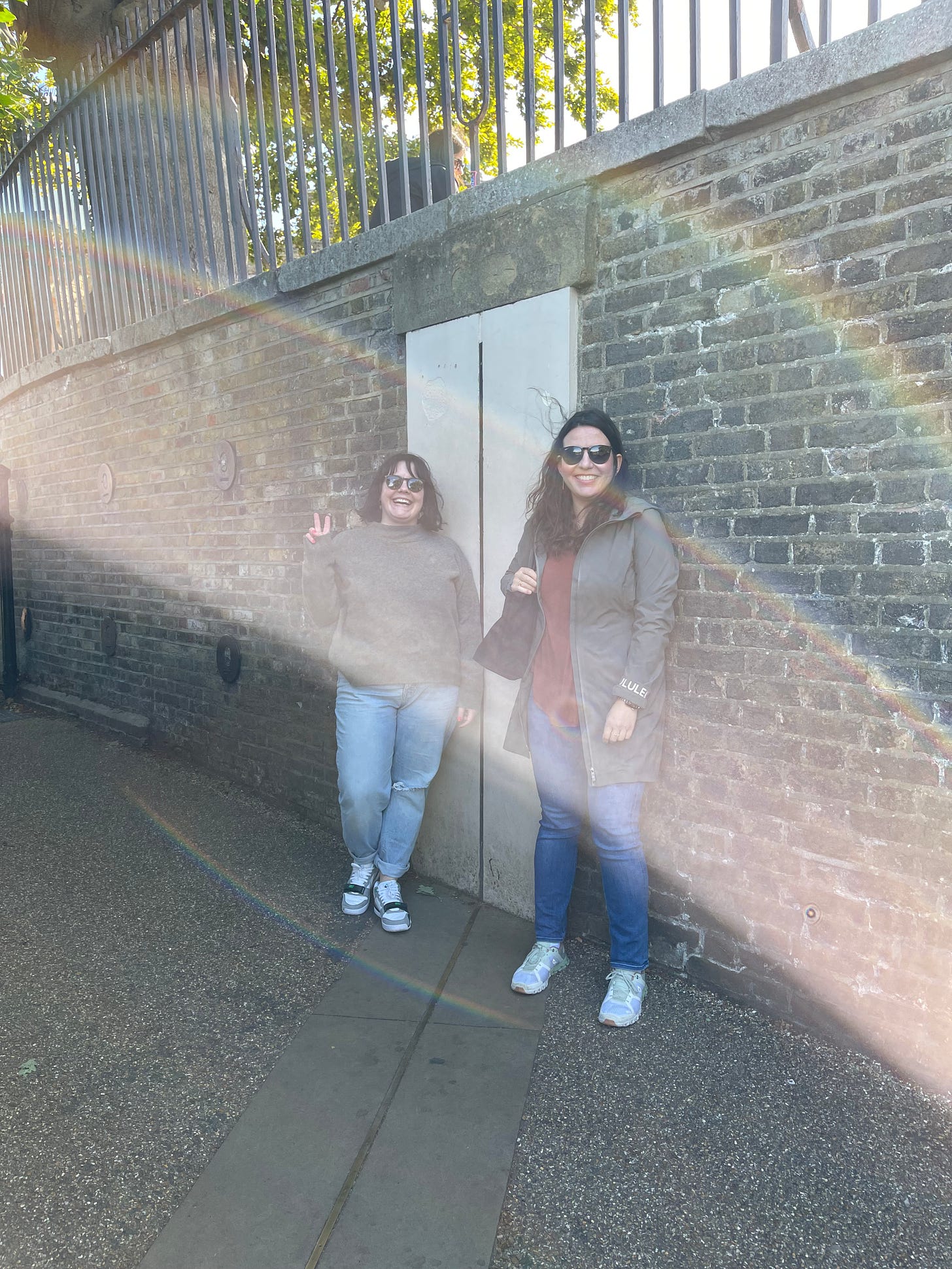 Me, in a green sweater, jeans, and air trainers, on one side of the prime meridian, and Julia, in a green coat and jeans, on the other side of it.