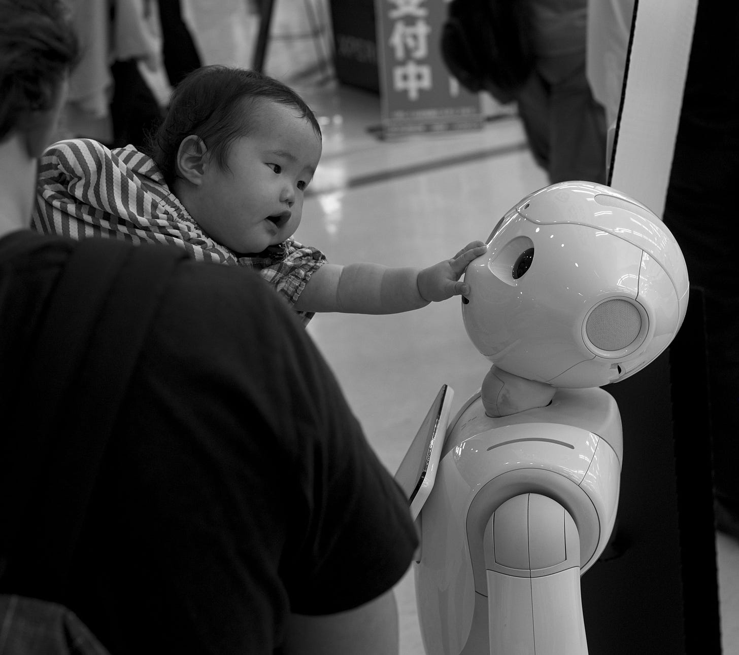 Picture of baby touching face of robot