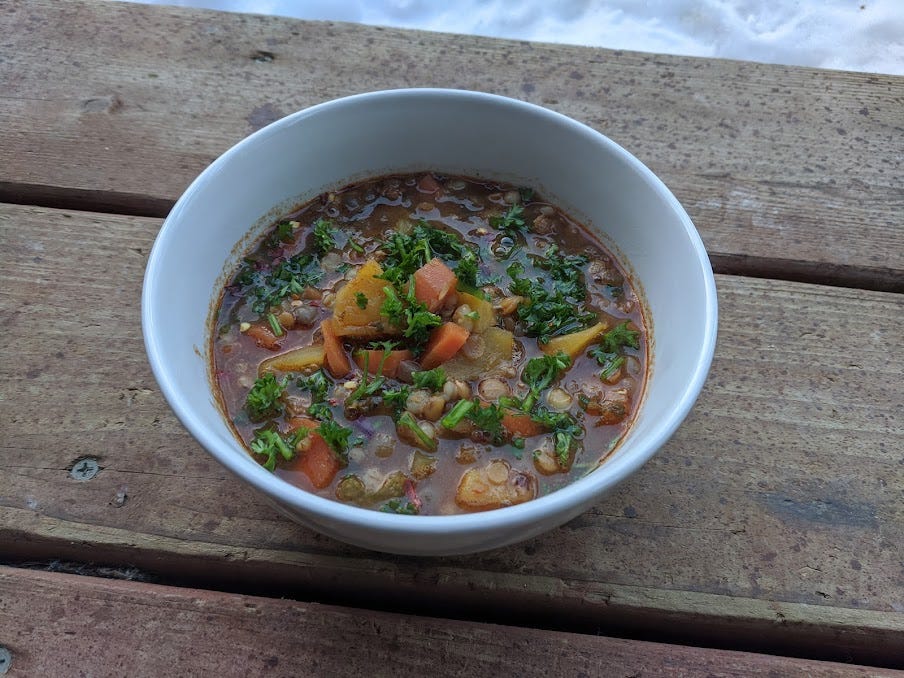 a bowl of lentil squash soup on the front porch