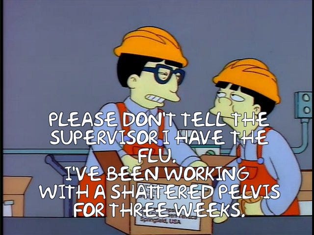 Animated image of two Japanese workers in a factory. One says to the other "please don't tell the supervisor I have the flu." The other responds by saying "I've been working with a shattered pelvis for three weeks."