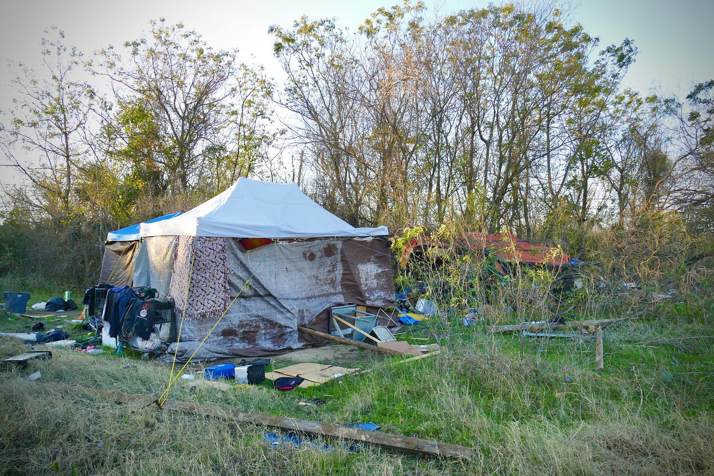 Picture of a homeless camp, with large and elaborately constructed tents made of a mix of bought and found materials
