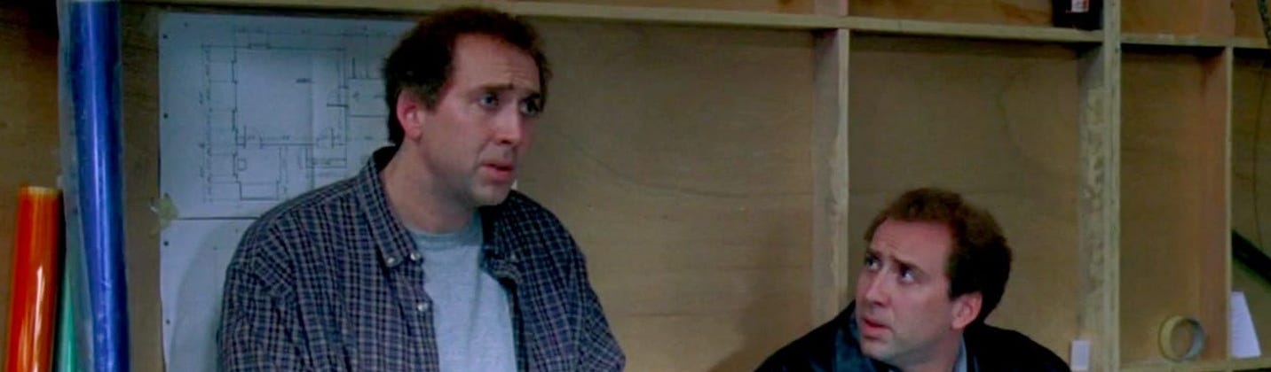 Still uit de film Adaption (2002). Je ziet twee keer Nicholas Cage verward kijken, voor een houten muur met tekeningen er op.