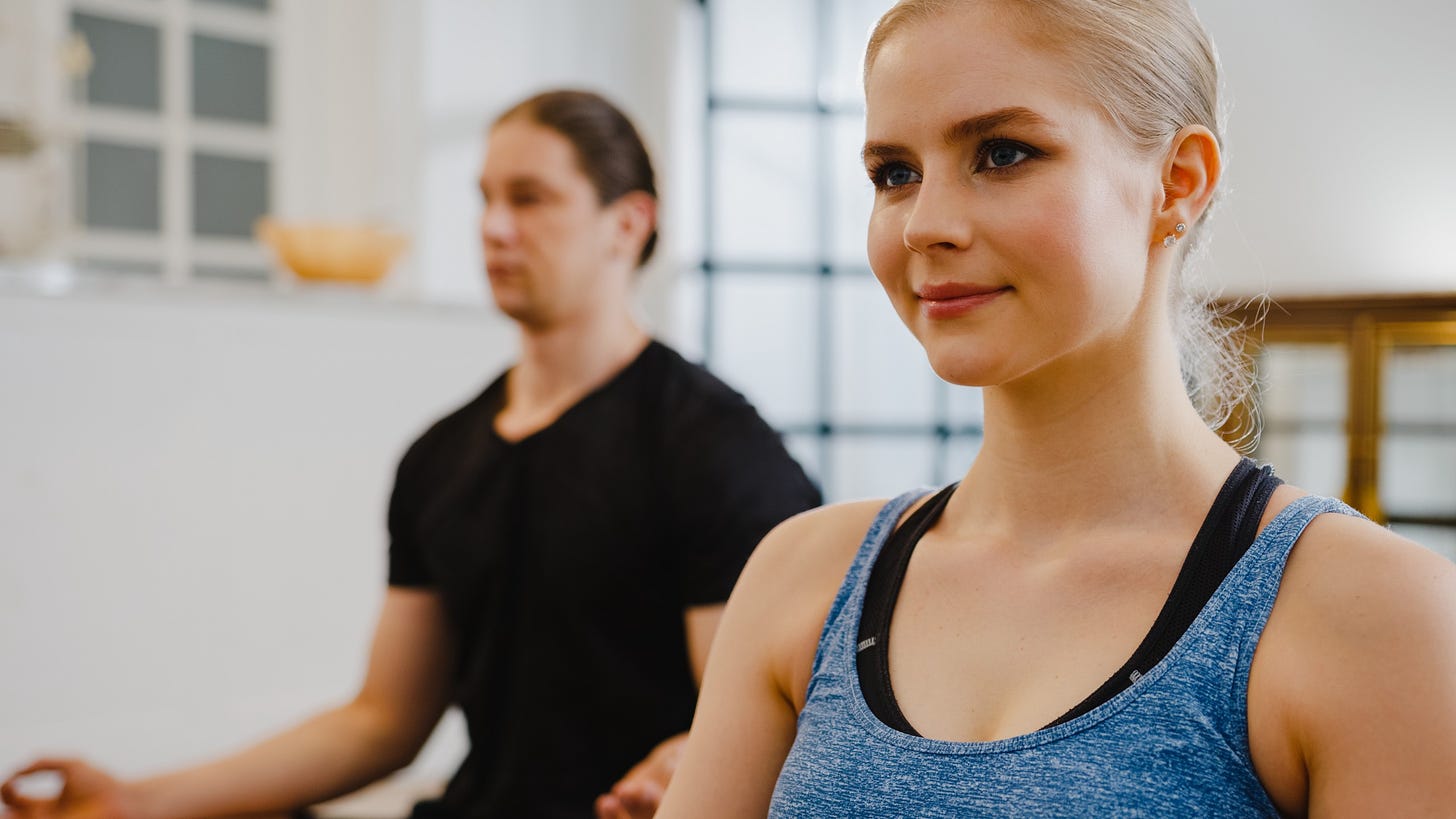 Young couple in sportswear doing yoga together.