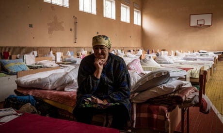 Anna Koval, 72, recounts her sorrows from her bed in a school gym in Kryvyi Rih
