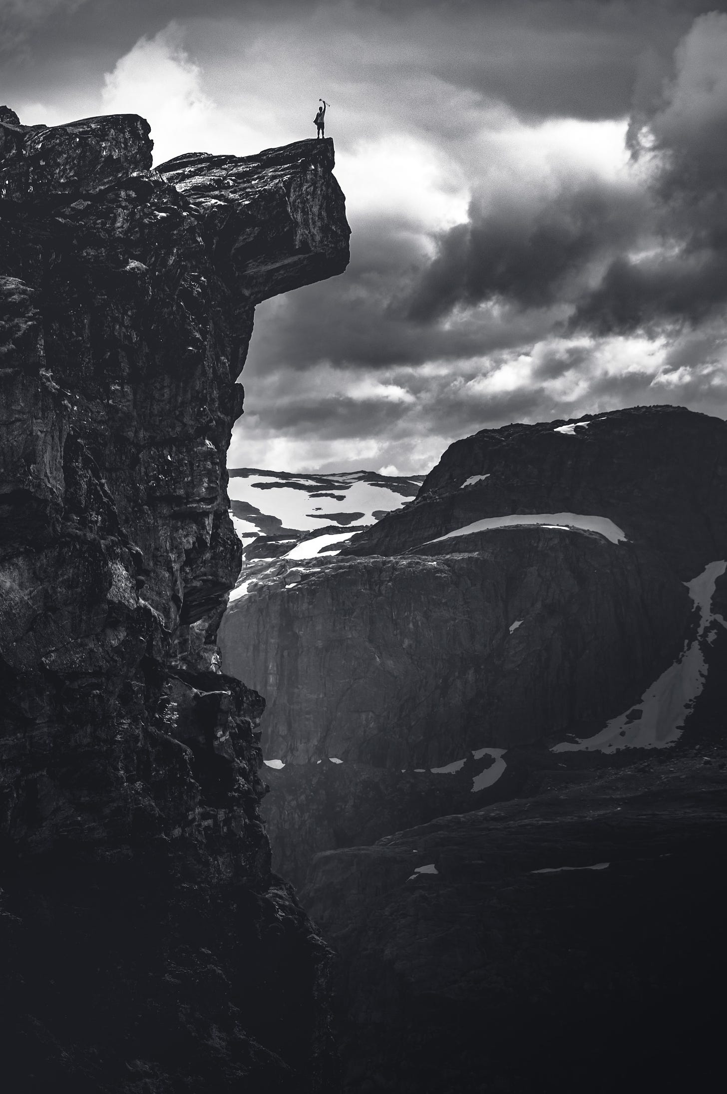 imagem em preto e branco de uma paisagem com um abismo e montanhas ao fundo