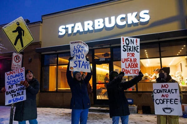 Four protesters outside a Starbucks store. 