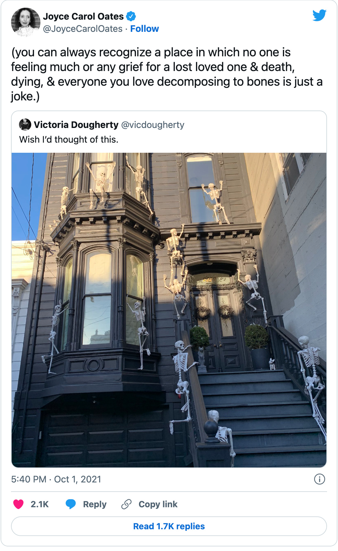 Classic JCO tweet from October 1, 2021 embedding a picture of a Victorian rowhouse with fake Halloween skeleton decorations attached to look like they’re climbing up it. Joyce’s commentary is: “(you can always recognize a place in which no one is feeling much or any grief for a lost loved one & death, dying, & everyone you love decomposing to bones is just a joke.)”
