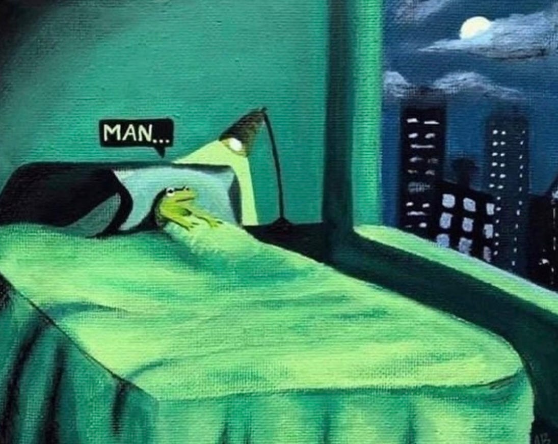 painted frog in bed with green sheets all lit by a floor lamp. frog is saying "man..." as it looks out a window overlooking a city at night