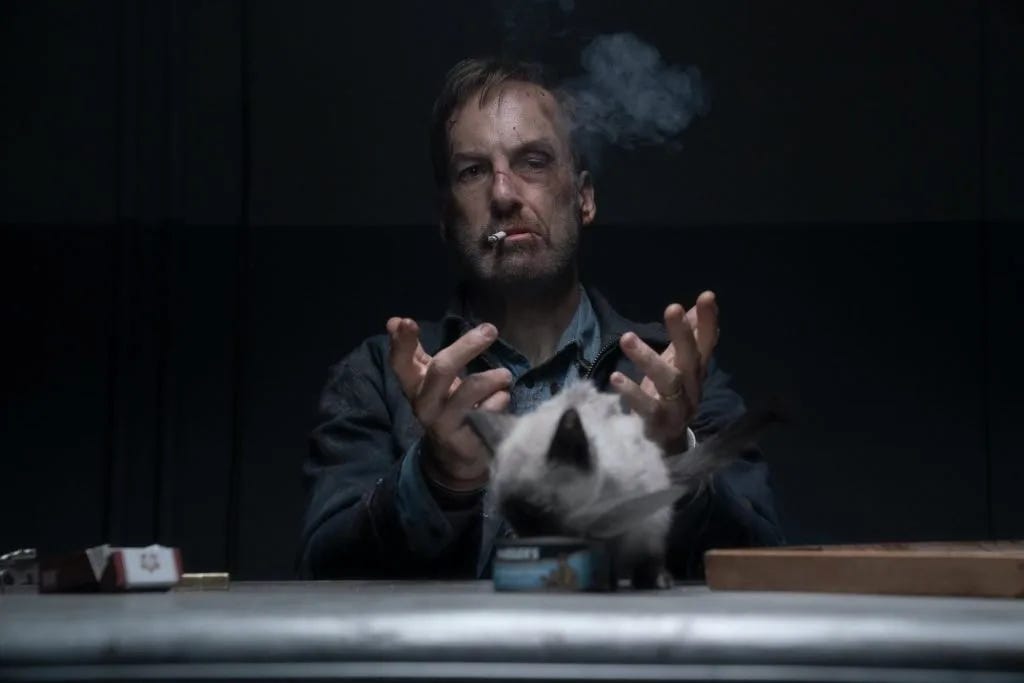 Hutch smoking on a cigarette with a cat.