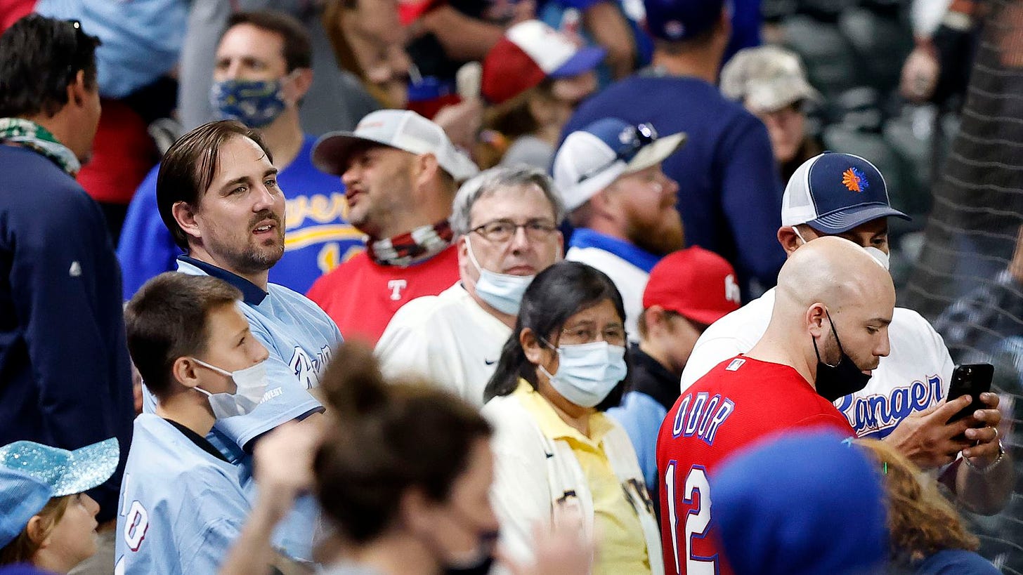 Texas Rangers fans, some with and without masks watch an exhibition game in the seventh inning at Globe Life Field in Arlington, Texas. The Rangers were facing the Brewers, Monday, March 29, 2021.