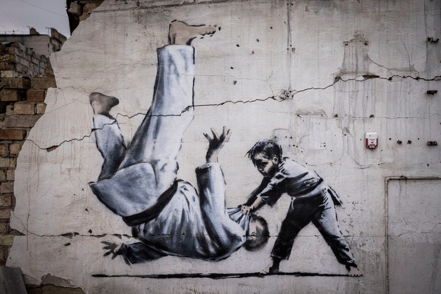 Graffiti of a child throwing a man on the floor in judo clothing is seen on a wall amid damaged buildings in Borodyanka on November 11, 2022 in Kyiv Region, Ukraine. The art work has sparked online speculation over whether the graffiti artist Banksy has been working in Ukraine.