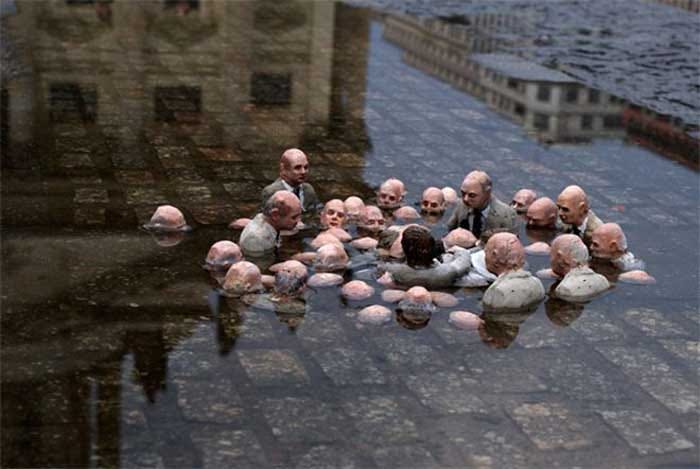 A statue of men in suits talking, with water rising around them