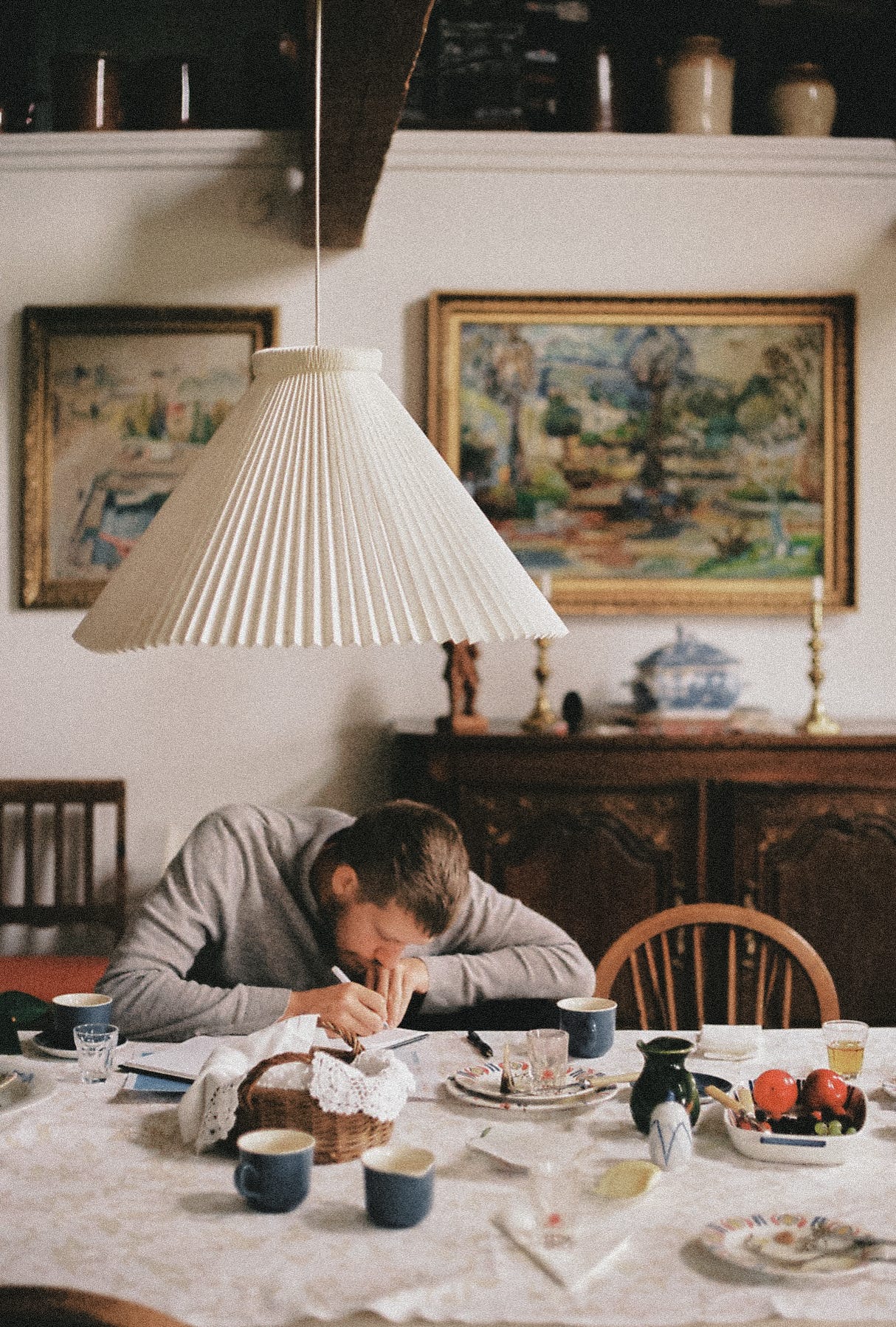 A photo of me writing a note, sitting in an old-fashioned B&B in Stevns Klint, Denmark. The photo is from before Uno was born and the grey sweater that I am wearing is no longer with me. However, I maintain the same haircut: short.