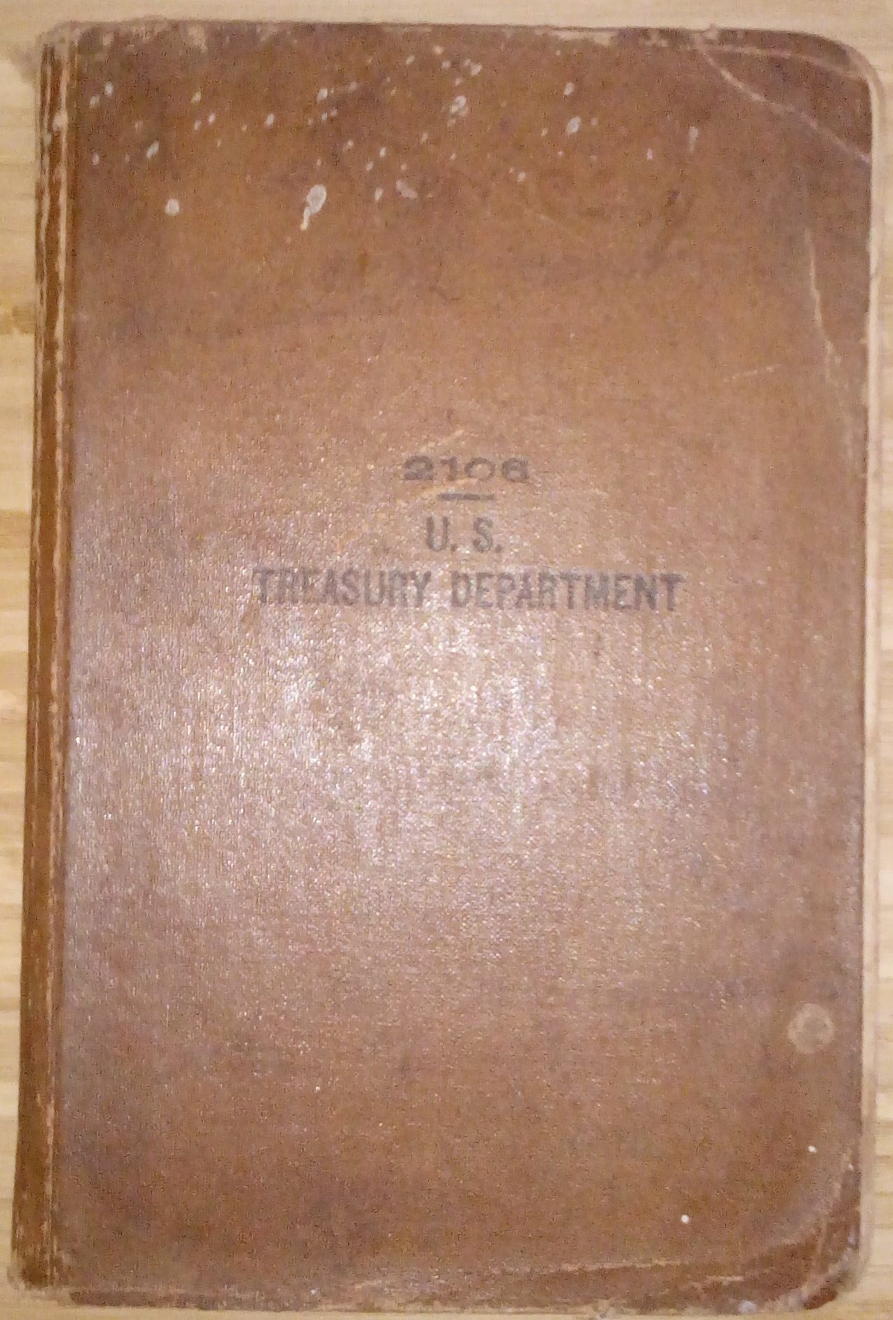 Photograph of a brown book with the words “2106 – U.S. Treasury Department” printed on it in black