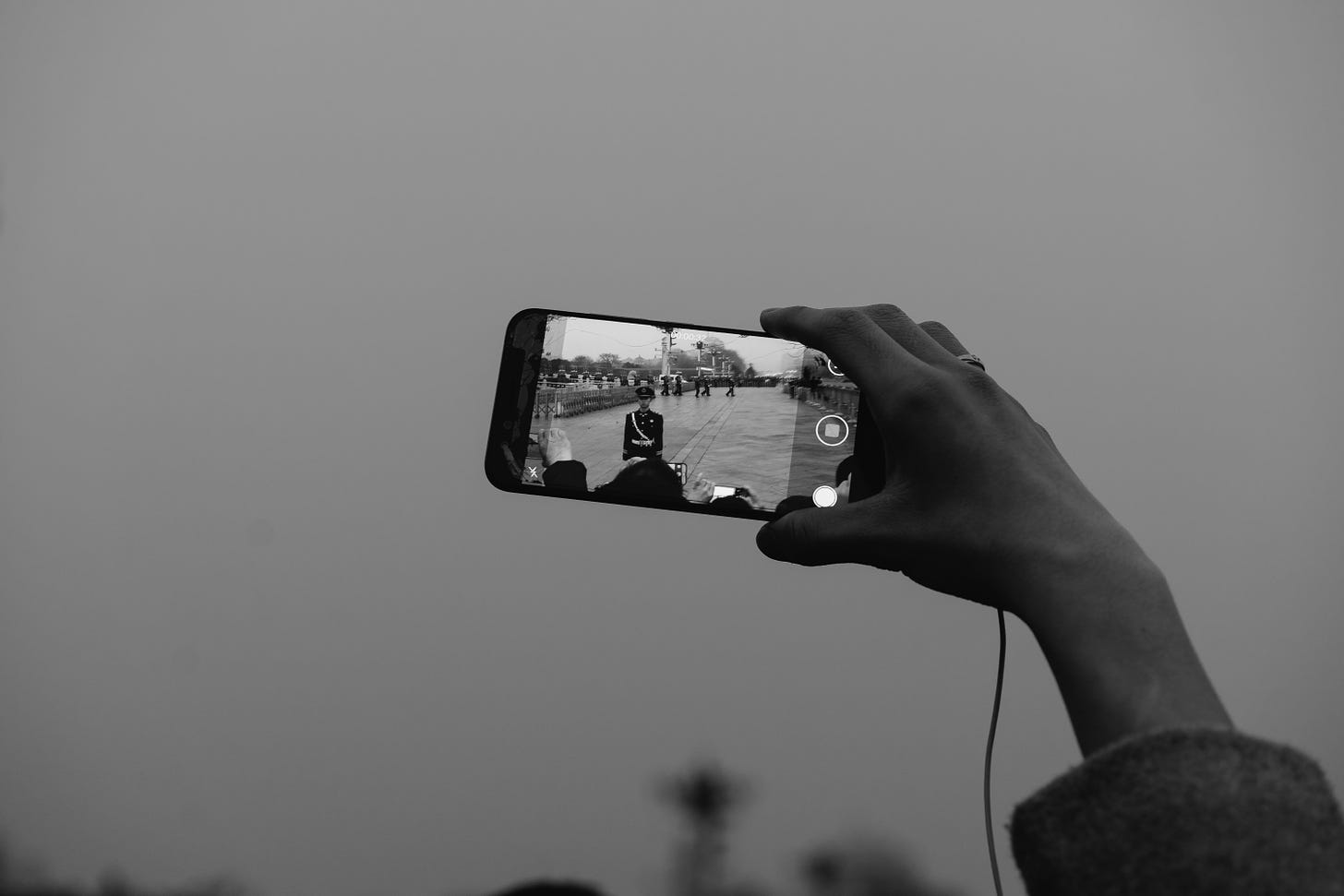Grayscale photo of a hand holding an iphone taking video. Markus Winkler / Unsplash
