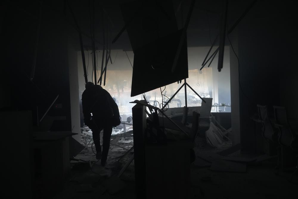 A journalist walks inside a damaged gym following shelling in Kyiv, Ukraine, Wednesday, March 2, 2022. Russian forces have escalated their attacks on crowded cities in what Ukraine's leader called a blatant campaign of terror. (AP Photo/Efrem Lukatsky)